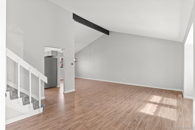 unfurnished living room featuring stairs, wood finished floors, and baseboards