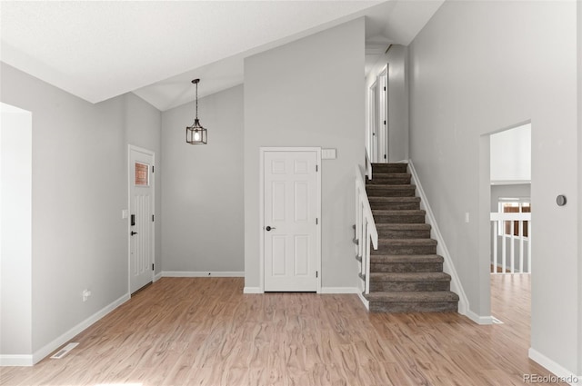 entrance foyer featuring stairway, light wood-style floors, visible vents, and baseboards