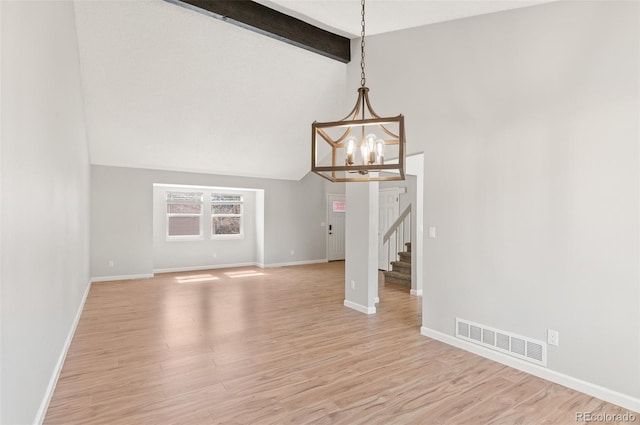 unfurnished dining area featuring light wood finished floors, visible vents, vaulted ceiling with beams, and stairs