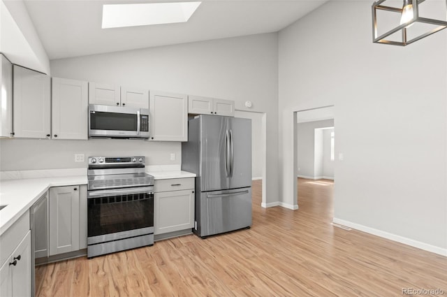 kitchen with light countertops, gray cabinetry, light wood finished floors, and stainless steel appliances