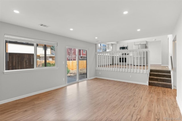 unfurnished living room featuring recessed lighting, baseboards, and light wood-style floors