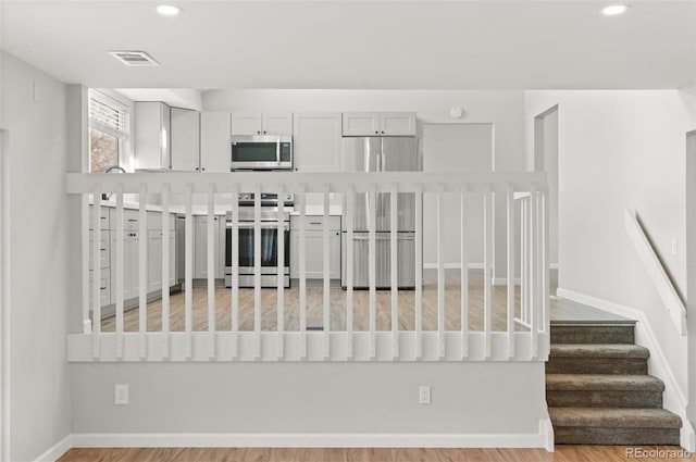 interior space with baseboards, recessed lighting, visible vents, and stainless steel appliances