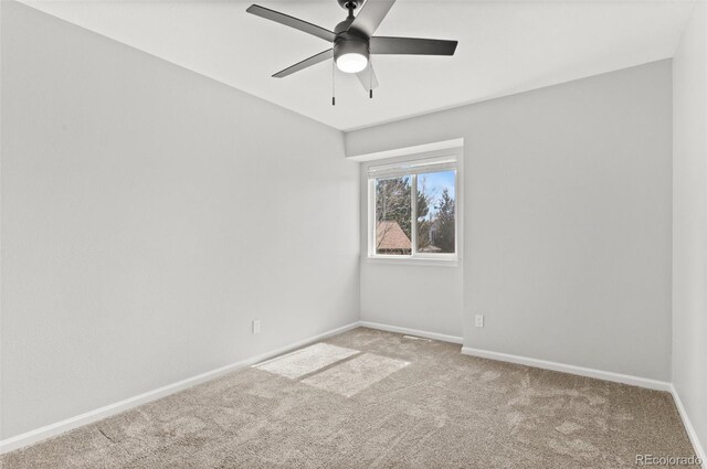 carpeted spare room with baseboards and ceiling fan