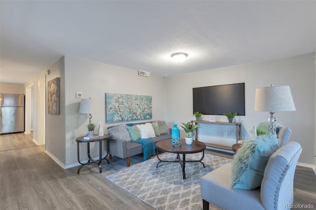 living room with hardwood / wood-style floors and a textured ceiling