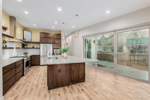 1848 W 68th Ave, Denver, CO 80221 - kitchen featuring open shelves, appliances with stainless steel finishes, wall chimney exhaust hood, light wood-style flooring, and a kitchen island with sink