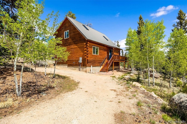 146 Atoka Dr, Como, CO 80432 - view of home's exterior with stairs, log exterior, a deck, a metal roof, and driveway