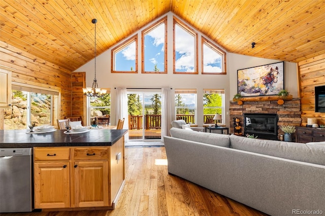 146 Atoka Dr, Como, CO 80432 - living area featuring high vaulted ceiling, a stone fireplace, wood walls, a chandelier, and light wood-type flooring