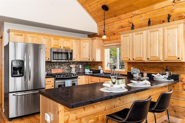 146 Atoka Dr, Como, CO 80432 - kitchen with appliances with stainless steel finishes, light brown cabinets, a peninsula, decorative backsplash, and tile countertops