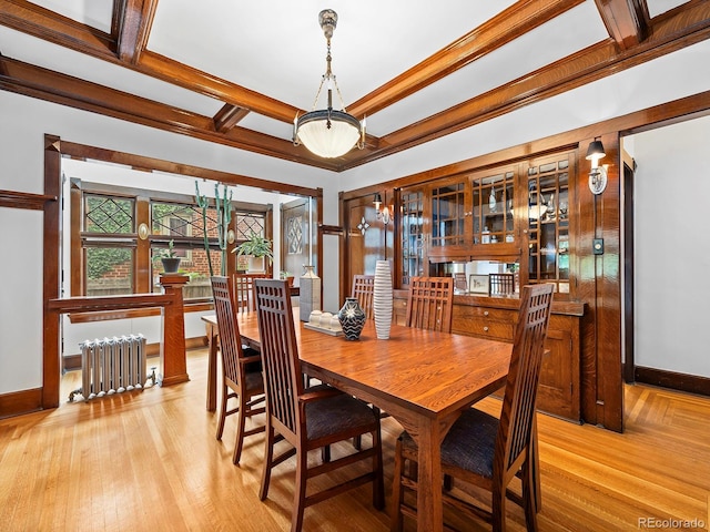 dining area featuring radiator, beamed ceiling, coffered ceiling, crown molding, and light wood-type flooring