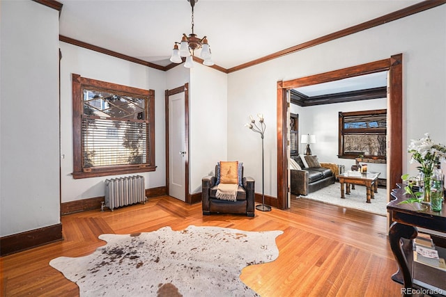 living area with a chandelier, crown molding, radiator, and hardwood / wood-style flooring