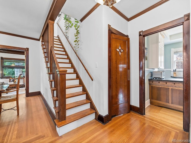 staircase with parquet floors and crown molding