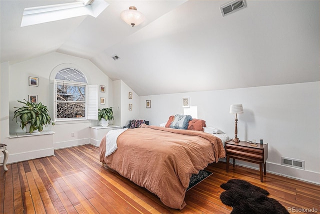 bedroom with hardwood / wood-style flooring and lofted ceiling with skylight