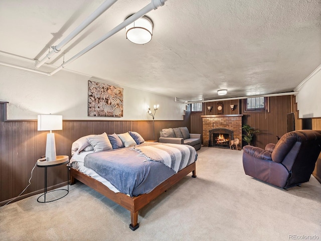 bedroom featuring a brick fireplace, wooden walls, light colored carpet, and a textured ceiling