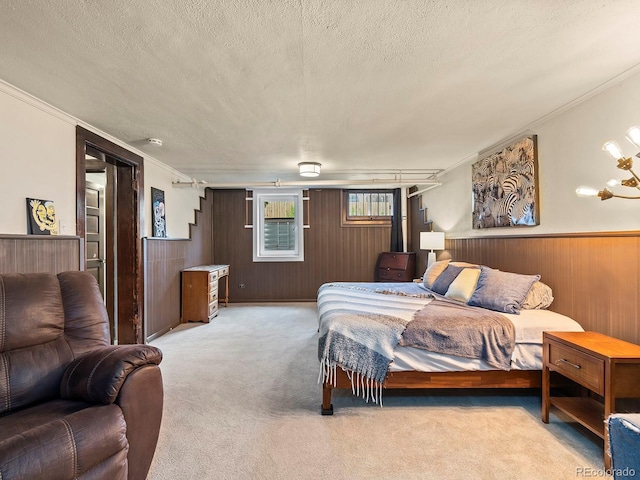 carpeted bedroom featuring ornamental molding, wooden walls, and a textured ceiling