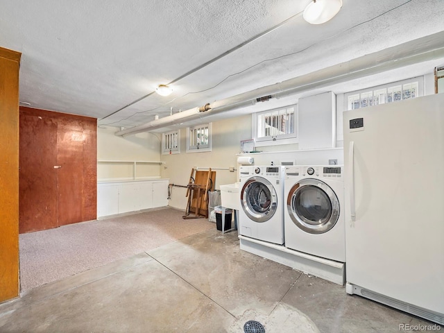 laundry area with plenty of natural light, washer and dryer, and a textured ceiling