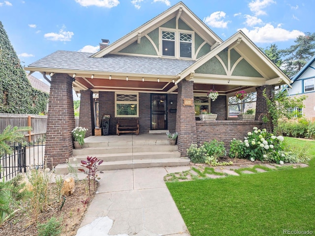 view of front of house with covered porch and a front yard