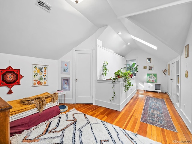 bedroom featuring vaulted ceiling with skylight and light wood-type flooring