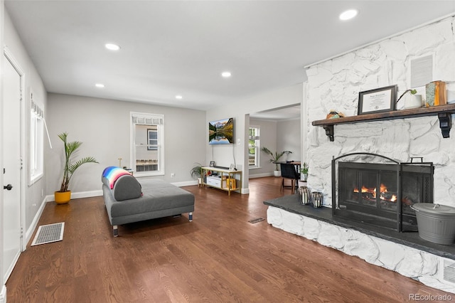 living room with dark hardwood / wood-style flooring and a fireplace