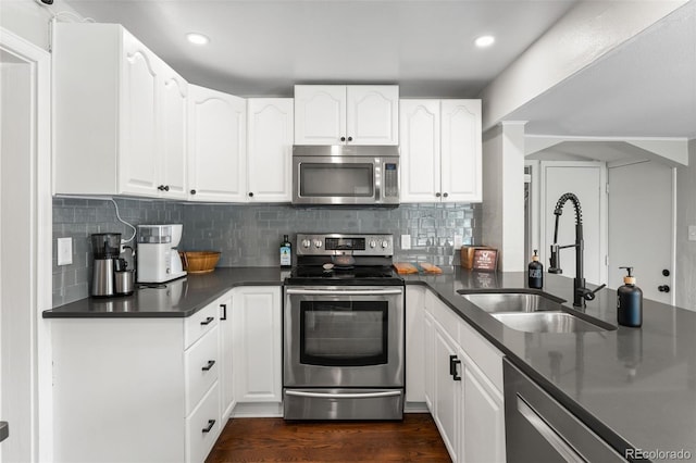 kitchen with stainless steel appliances, white cabinetry, sink, and tasteful backsplash