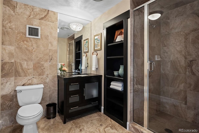 bathroom featuring toilet, vanity, tile walls, and an enclosed shower