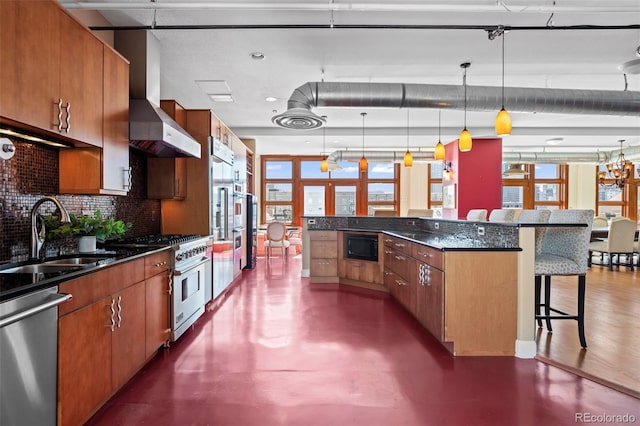 kitchen with appliances with stainless steel finishes, tasteful backsplash, hanging light fixtures, a breakfast bar, and sink