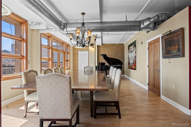 dining area with a notable chandelier and light wood-type flooring