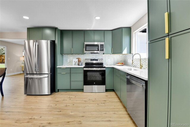 10431 Holland St, Broomfield, CO 80021 - kitchen with green cabinets, appliances with stainless steel finishes, a sink, and recessed lighting