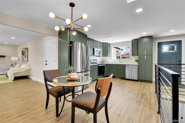 10431 Holland St, Broomfield, CO 80021 - dining area with light wood-style floors, baseboards, a chandelier, and recessed lighting