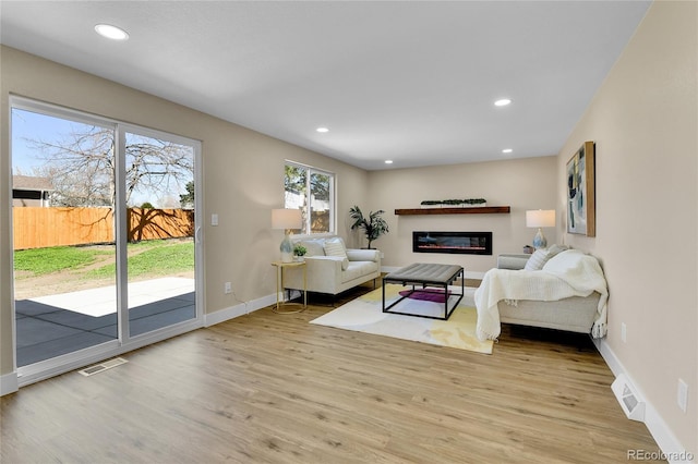 10431 Holland St, Broomfield, CO 80021 - living room with wood finished floors, baseboards, recessed lighting, and a glass covered fireplace