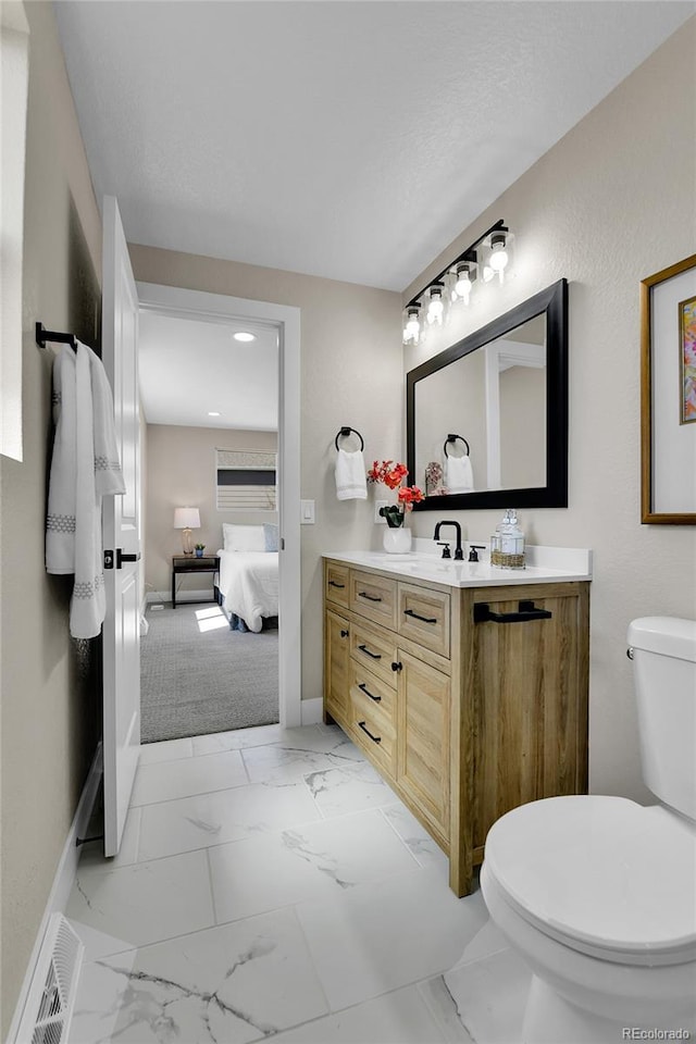 10431 Holland St, Broomfield, CO 80021 - bathroom with toilet, marble finish flooring, vanity, connected bathroom, and baseboards