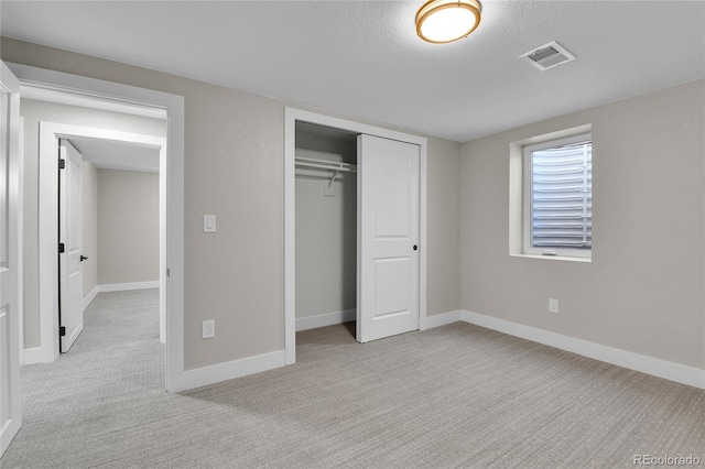 10431 Holland St, Broomfield, CO 80021 - unfurnished bedroom with light colored carpet, baseboards, a textured ceiling, and a closet