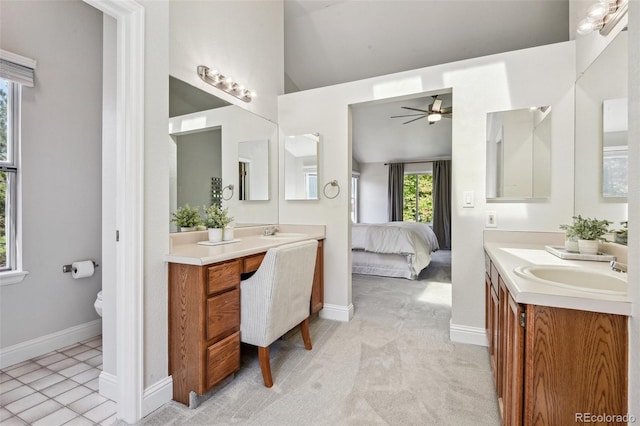 bathroom featuring ceiling fan, toilet, vanity, and vaulted ceiling