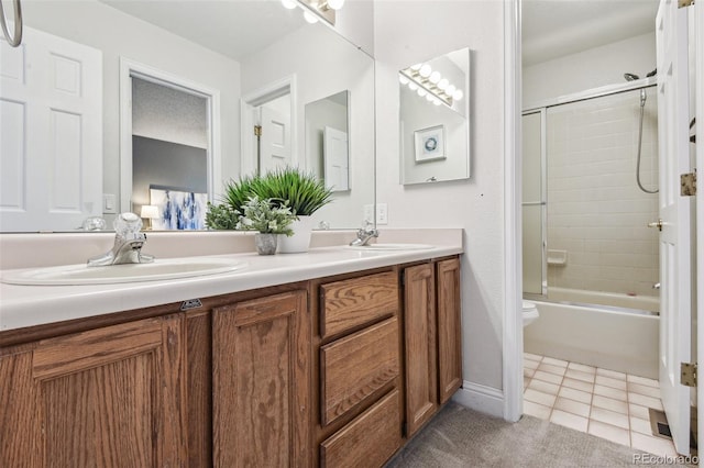 full bathroom featuring tile patterned floors, vanity, enclosed tub / shower combo, and toilet