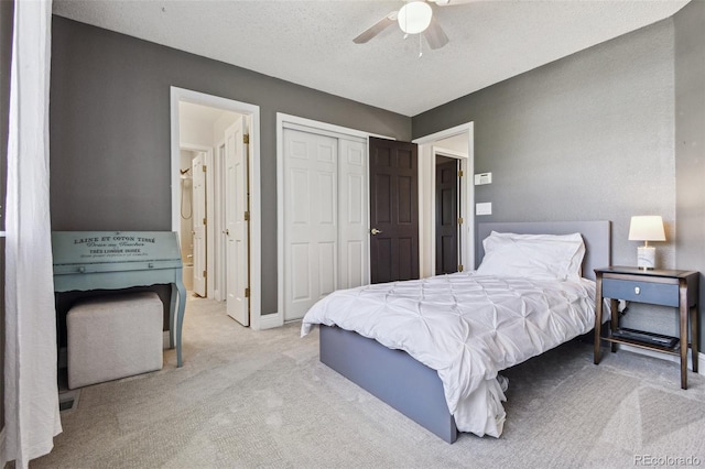 carpeted bedroom featuring ceiling fan, a textured ceiling, and a closet