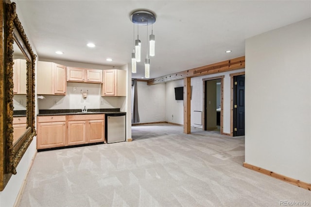 kitchen with light brown cabinetry, refrigerator, light colored carpet, and hanging light fixtures