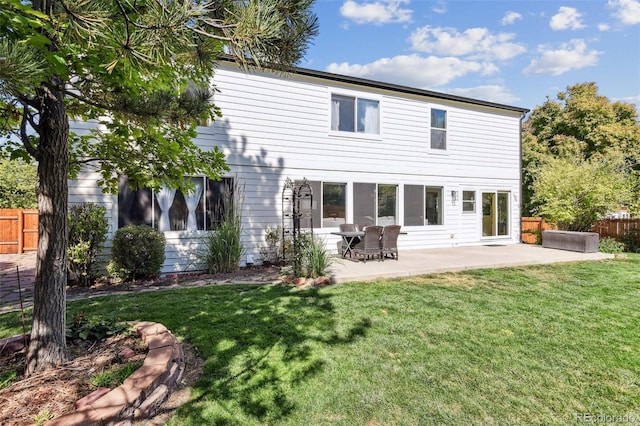 rear view of property featuring a yard and a patio area