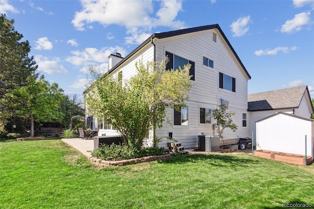 rear view of property featuring cooling unit, a yard, and a patio