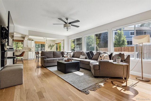 living room with light hardwood / wood-style flooring and ceiling fan