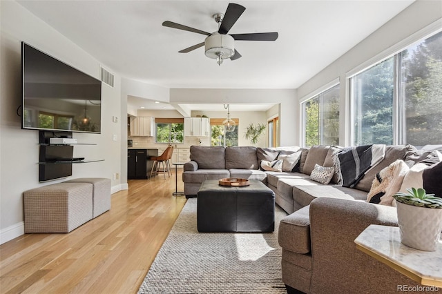 living room featuring light hardwood / wood-style flooring and ceiling fan