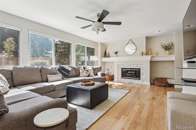 living room featuring a fireplace, hardwood / wood-style flooring, and ceiling fan