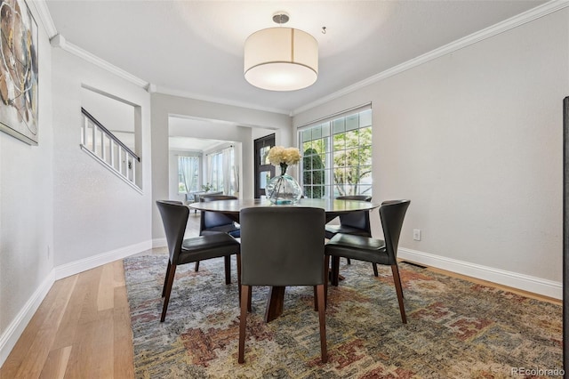 dining space featuring hardwood / wood-style floors and ornamental molding