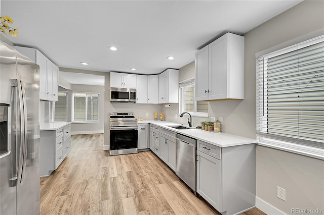 3890 S Atchison Way Unit B, Aurora, CO 80014 - kitchen featuring appliances with stainless steel finishes, light wood-type flooring, light countertops, recessed lighting, and white cabinetry