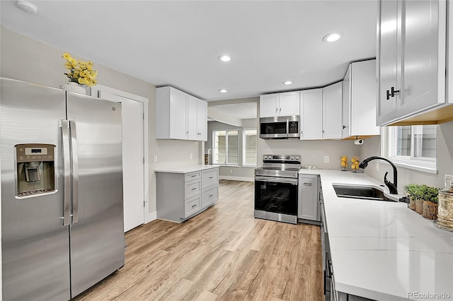 3890 S Atchison Way Unit B, Aurora, CO 80014 - kitchen featuring appliances with stainless steel finishes, light countertops, light wood-type flooring, recessed lighting, and white cabinets