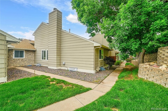 3890 S Atchison Way Unit B, Aurora, CO 80014 - view of property exterior with a chimney and a lawn
