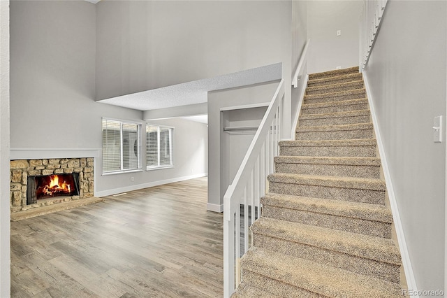3890 S Atchison Way Unit B, Aurora, CO 80014 - stairs featuring a towering ceiling, wood finished floors, and a fireplace