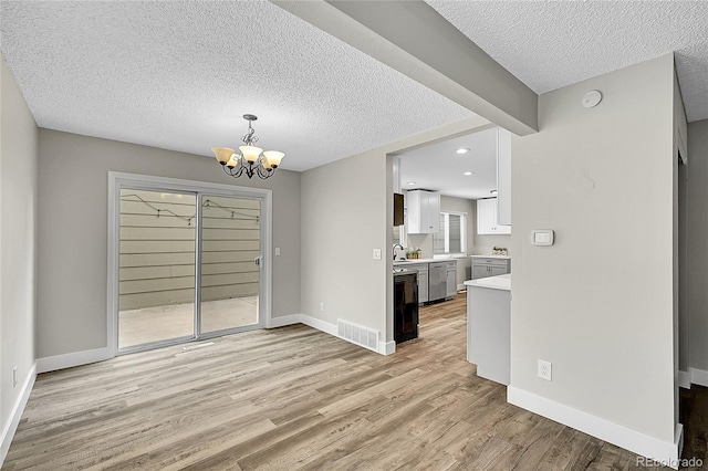 3890 S Atchison Way Unit B, Aurora, CO 80014 - unfurnished dining area featuring light wood-type flooring, a chandelier, a textured ceiling, and recessed lighting