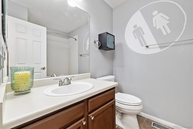 bathroom with tile patterned flooring, toilet, visible vents, vanity, and a shower