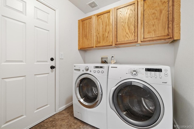 washroom with cabinet space, baseboards, visible vents, and independent washer and dryer