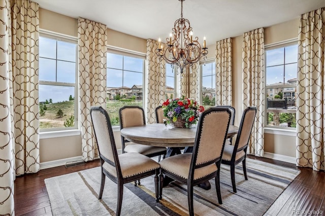 dining area featuring dark hardwood / wood-style flooring and an inviting chandelier