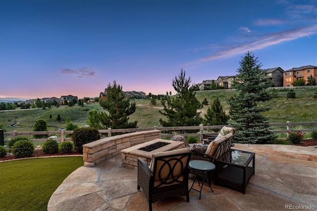 patio terrace at dusk featuring an outdoor fire pit